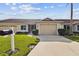 House exterior featuring a two-car garage and well-manicured lawn at 1709 Edgewater Ln, Palmetto, FL 34221