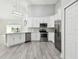 Modern kitchen featuring white cabinets, stainless steel appliances, and grey flooring at 1709 Edgewater Ln, Palmetto, FL 34221