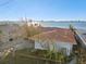 Aerial view of waterfront home with tile roof and mature landscaping at 1836 Venetian Point Dr, Clearwater, FL 33755