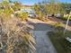 House on tree lined street with driveway and palm trees at 1836 Venetian Point Dr, Clearwater, FL 33755