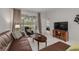 Spacious living area with a leather sectional, coffee table, and view to a tranquil backyard at 3143 Brooker Creek Way, Palm Harbor, FL 34685