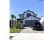 Two-story home with gray garage door and landscaping at 4861 Tramanto Ln, Wesley Chapel, FL 33543