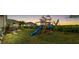 Spacious backyard featuring a playground and hot tub at dusk at 6189 Hidden Branch Dr, Apollo Beach, FL 33572