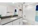 Bathroom with dark vanity, white cabinets, and a bathtub at 6189 Hidden Branch Dr, Apollo Beach, FL 33572