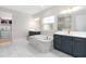 Luxurious bathroom with double vanities, soaking tub, walk-in shower, and marble tile at 6189 Hidden Branch Dr, Apollo Beach, FL 33572