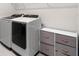 Laundry room with front load washer and dryer and storage at 6189 Hidden Branch Dr, Apollo Beach, FL 33572