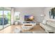 Comfortable living area with large TV, light colored sofas, and backyard access at 6189 Hidden Branch Dr, Apollo Beach, FL 33572