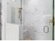 Large walk-in shower with marble tile and glass enclosure at 6189 Hidden Branch Dr, Apollo Beach, FL 33572