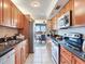Modern kitchen with wood cabinets, granite countertops, and stainless steel appliances at 660 Island Way # 1005, Clearwater Beach, FL 33767