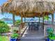 Outdoor dining space with thatch roof and waterfront views at 660 Island Way # 1005, Clearwater Beach, FL 33767
