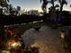 Backyard patio with fire pit and water feature at night at 10626 Restoration Ter, Bradenton, FL 34212