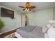 Spacious bedroom with wood floors, ceiling fan, and large TV at 1116 Flora Vista St, Trinity, FL 34655