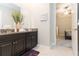 Double vanity bathroom with granite countertop and access to bedroom at 11714 Sunburst Marble Rd, Riverview, FL 33579
