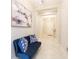 Elegant entryway with tiled floor, blue velvet settee, and art at 11714 Sunburst Marble Rd, Riverview, FL 33579