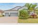 Two-story house with gray siding, three-car garage, and lush landscaping at 11714 Sunburst Marble Rd, Riverview, FL 33579