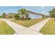 Side view of a house with gray siding, landscaping, and sidewalk at 11714 Sunburst Marble Rd, Riverview, FL 33579