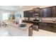 Modern kitchen with dark cabinetry, granite countertops, and stainless steel appliances at 11714 Sunburst Marble Rd, Riverview, FL 33579