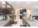 Modern kitchen with island, dark cabinets and granite countertops at 11714 Sunburst Marble Rd, Riverview, FL 33579