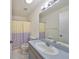 Clean bathroom with shower/tub combo and floral shower curtain at 1936 Grand Cypress Ln, Sun City Center, FL 33573