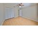 Simple bedroom with light wood flooring, double door closet and ceiling fan at 1936 Grand Cypress Ln, Sun City Center, FL 33573