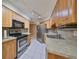 Bright kitchen with stainless steel appliances and light wood cabinets at 1936 Grand Cypress Ln, Sun City Center, FL 33573