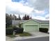 Light green house with a two-car garage and well-manicured landscaping at 20841 Eustis Rd, Land O Lakes, FL 34637