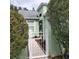 Pathway to the entrance of a light green house with lush landscaping at 20841 Eustis Rd, Land O Lakes, FL 34637
