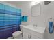 Bathroom with white vanity, blue shower curtain, and mirror at 2401/2403 23Rd W Ave, Bradenton, FL 34205