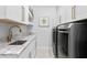 Bright laundry room, featuring white cabinets, granite countertops, and a stylish sink at 2502 S Dundee St, Tampa, FL 33629