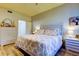 Well-lit bedroom with floral bedding and light wood furniture at 3000 Red Oak Court # 103, Palm Harbor, FL 34684