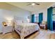 Spacious bedroom with floral bedding and teal curtains at 3000 Red Oak Court # 103, Palm Harbor, FL 34684