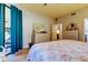 Bedroom with floral bedding, dresser, and sliding glass door to balcony at 3000 Red Oak Court # 103, Palm Harbor, FL 34684