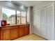 Bright kitchen boasts granite counters, wood cabinets, and laundry closet at 3000 Red Oak Court # 103, Palm Harbor, FL 34684
