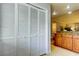 White louvered doors conceal a laundry area with shelving at 3000 Red Oak Court # 103, Palm Harbor, FL 34684