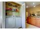Neat laundry room with washer, dryer, and shelving at 3000 Red Oak Court # 103, Palm Harbor, FL 34684