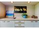Outdoor kitchen area with white cabinets and coastal decor at 3000 Red Oak Court # 103, Palm Harbor, FL 34684