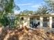 Back of house with patio, overgrown yard, and storage shed at 3613 S Gardenia Ave, Tampa, FL 33629