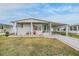 Single-wide manufactured home with covered porch and driveway at 36901 Kimela Ave, Zephyrhills, FL 33542