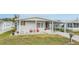 Single-wide manufactured home with covered porch and landscaping at 36901 Kimela Ave, Zephyrhills, FL 33542