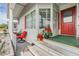 Inviting front porch with red chairs and planters at 36901 Kimela Ave, Zephyrhills, FL 33542
