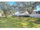 Spacious backyard with lush grass and mature trees at 37650 Aaralyn Rd, Zephyrhills, FL 33542