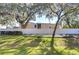 Backyard view of a white privacy fence and large oak trees at 37650 Aaralyn Rd, Zephyrhills, FL 33542