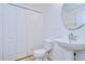 Small bathroom with pedestal sink, toilet, and linen closet at 37650 Aaralyn Rd, Zephyrhills, FL 33542