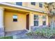 Front entrance of a yellow townhome with a brown door at 37650 Aaralyn Rd, Zephyrhills, FL 33542