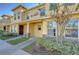 Tan two-story townhome with manicured hedges and landscaping at 37650 Aaralyn Rd, Zephyrhills, FL 33542
