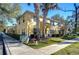 Tan two-story townhome with palm trees and manicured landscaping at 37650 Aaralyn Rd, Zephyrhills, FL 33542