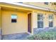 Front entrance of a yellow townhome with a brown door at 37650 Aaralyn Rd, Zephyrhills, FL 33542