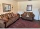 Living room features brown sofas, decorative pillows, and a maroon rug at 529 Carriage Hills Dr, Temple Terrace, FL 33617