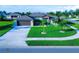 Single-Gathering house with a two-car garage, lush lawn, and palm trees at 8610 Quinn Ct, North Port, FL 34287