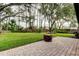 Large backyard with fire pit and lush green lawn at 8727 Huntfield St, Tampa, FL 33635